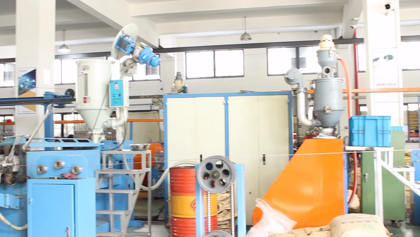 Industrial cable-processing machinery with reels in a workshop
