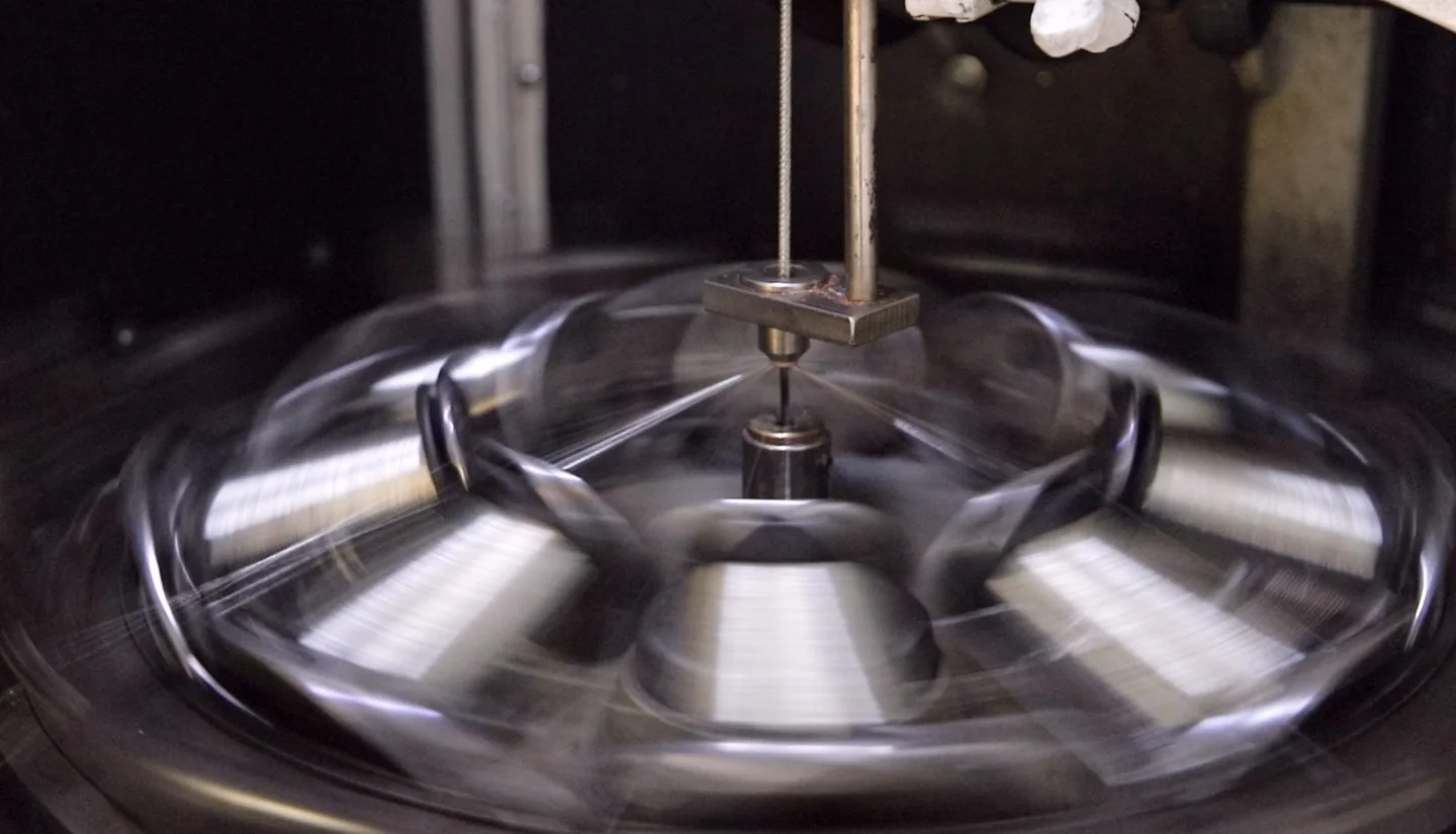 Close-up of industrial equipment processing metallic strands