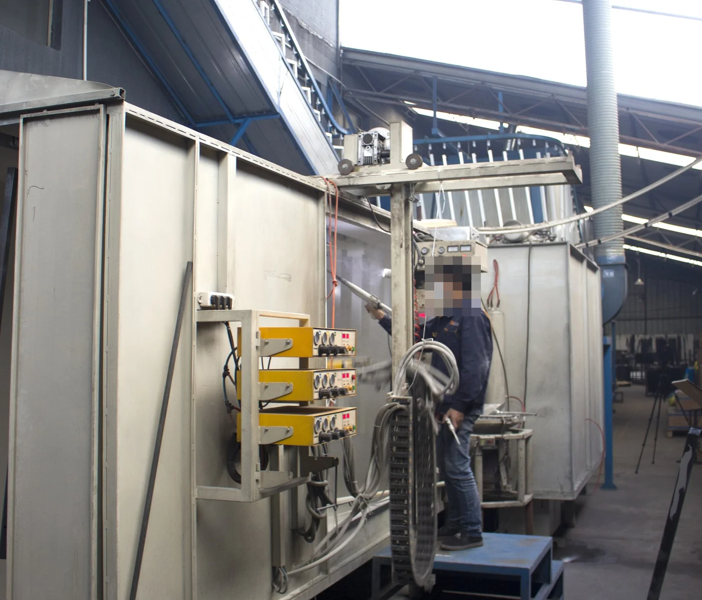 Operator working next to large industrial production equipment