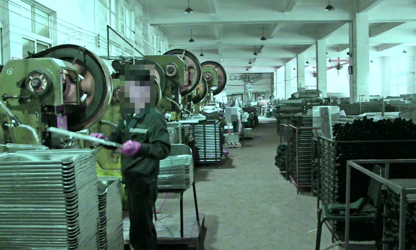 Worker operating machinery inside a metalworking workshop